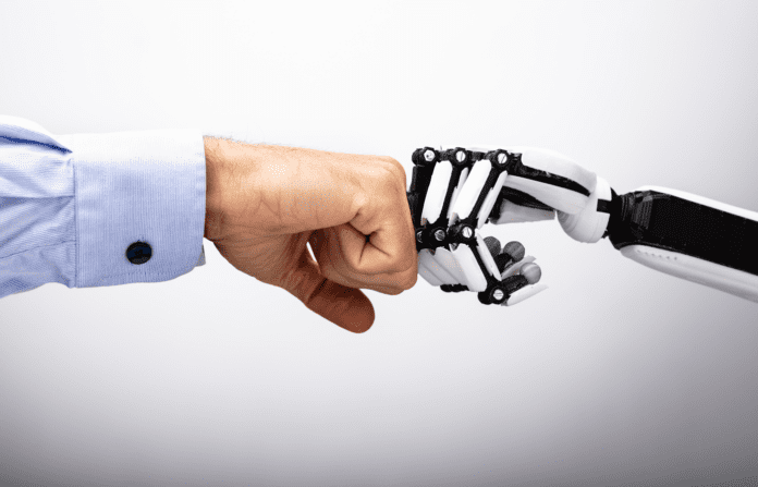 Human and robot hand making a fist bump.